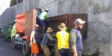 Petugas kebersihan DLHK Kabupaten Sidoarjo saat membersikan sampah di pinggir jalan.