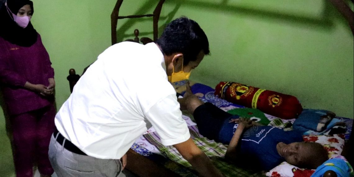 Adam Rusydi menengok penderita tumor di Dusun Kendal Desa Bakung Pringgodani, Kecamatan Balongbendo, Kabupaten Sidoarjo.