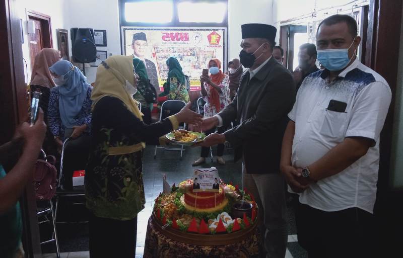 BHS menyerahkan potongan tumpeng untuk merayakan hari guru