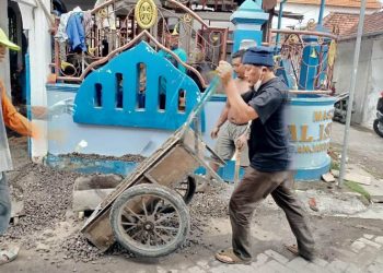 H Khulaim Junaidi saat turun tangan membantu mengerjakan renovasi masjid di Desa Banjarkemuning, Sidoarjo