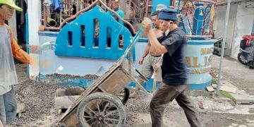 H Khulaim Junaidi saat turun tangan membantu mengerjakan renovasi masjid di Desa Banjarkemuning, Sidoarjo