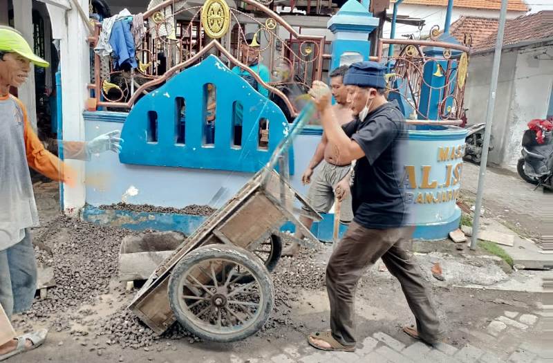H Khulaim Junaidi saat turun tangan membantu mengerjakan renovasi masjid di Desa Banjarkemuning, Sidoarjo
